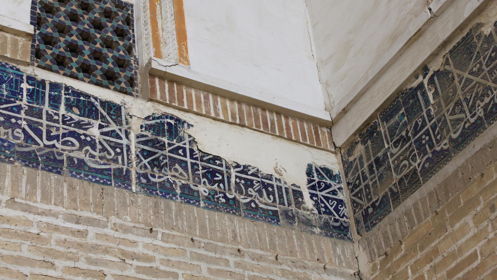 Das Bild zeigt ein besch?digtes Keramikfried an einer Wand in der Kukaldosh Medrese in Buchara.