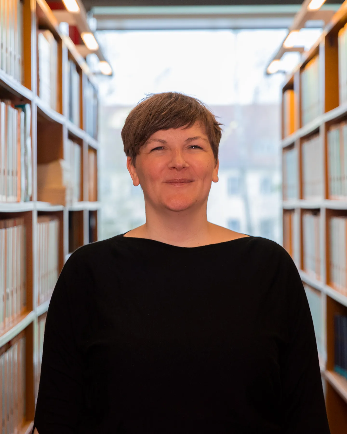 Portrait von Bibliothekswissenschaft-Studentin Tabea in der Bibliothek