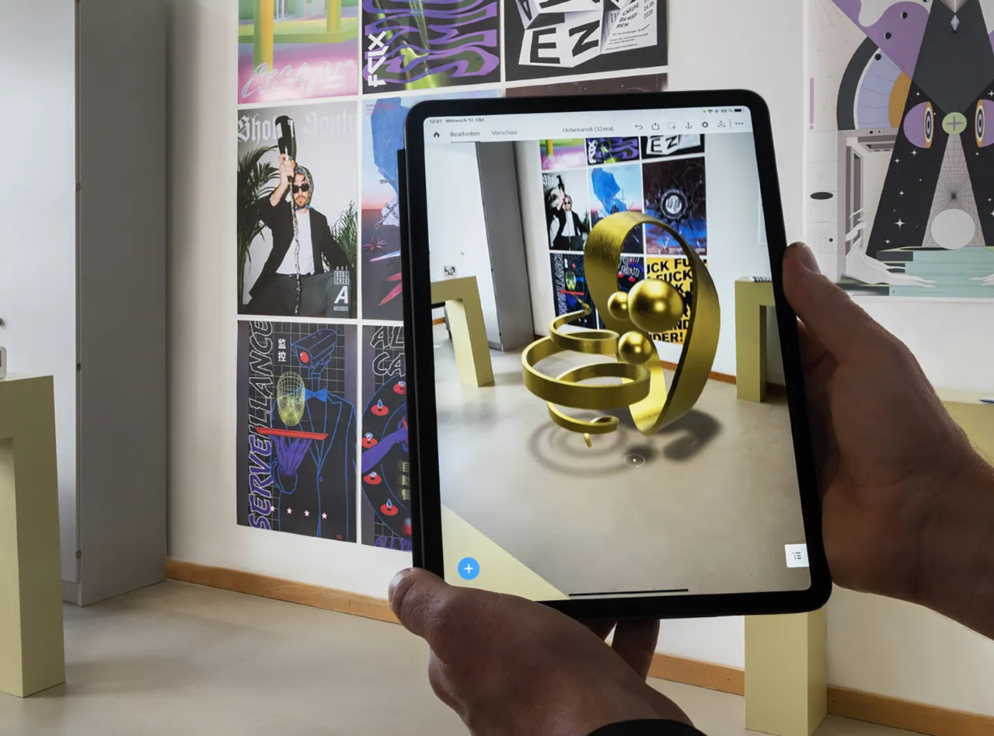 Zwei H?nde scannen mit einem iPad einen Raum, auf dem Bildschirm ist eine AR-Skulptur zu sehen