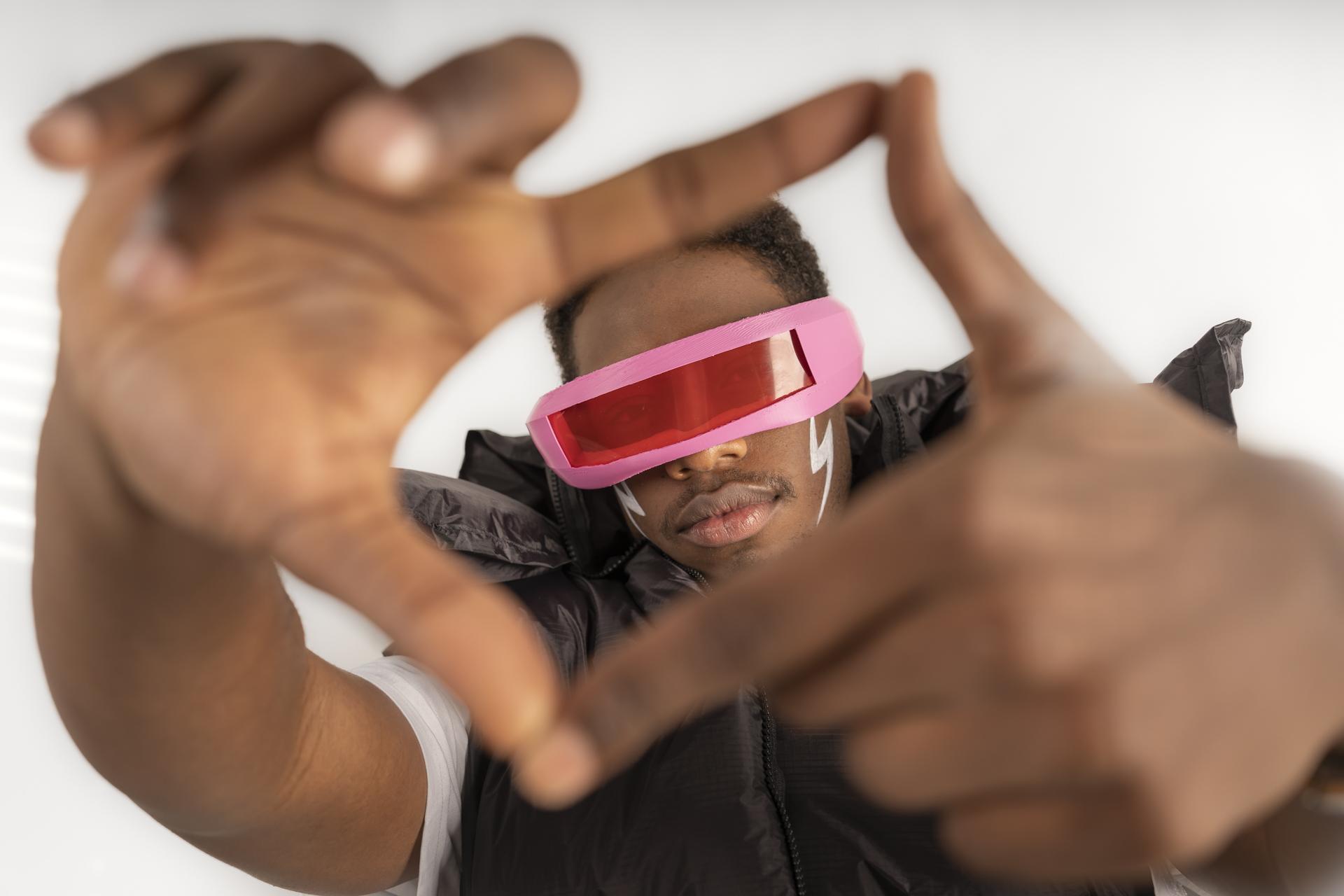 Studierender mit futuristischer Brille formt einen Rahmen mit seinen H?nden