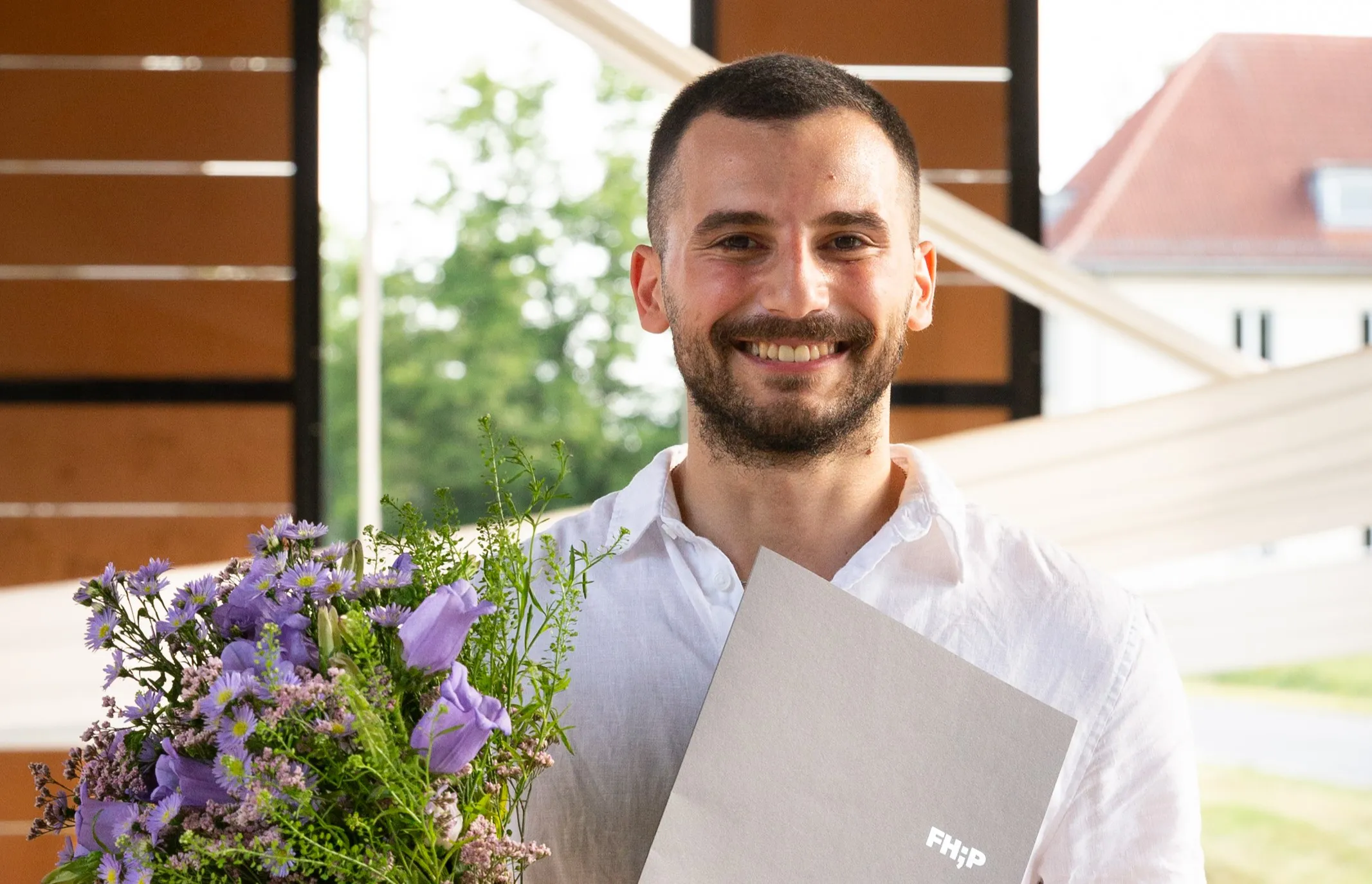 DAAD-Preistr?ger Hadi Daaboul mit Blumenstrauss und Urkunde