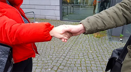 zwei Menschen reichen sich die Hand